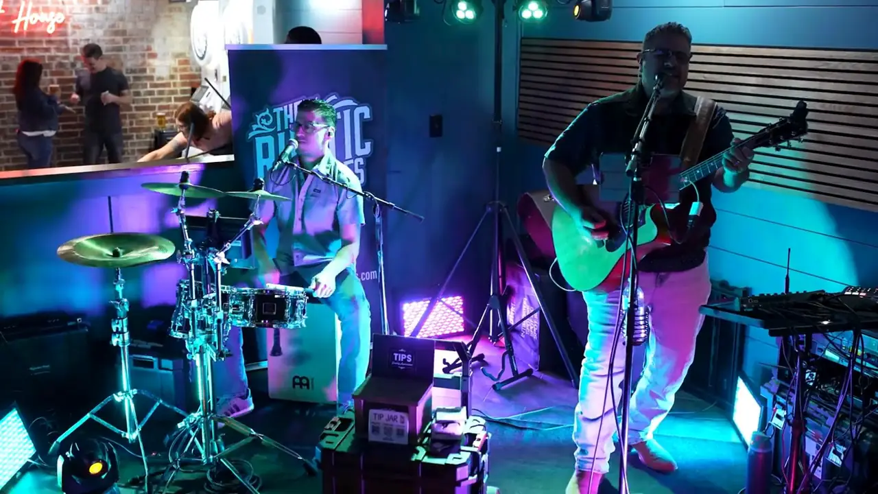 Acoustic guitarist and drummer performing at Lefty's live music bar